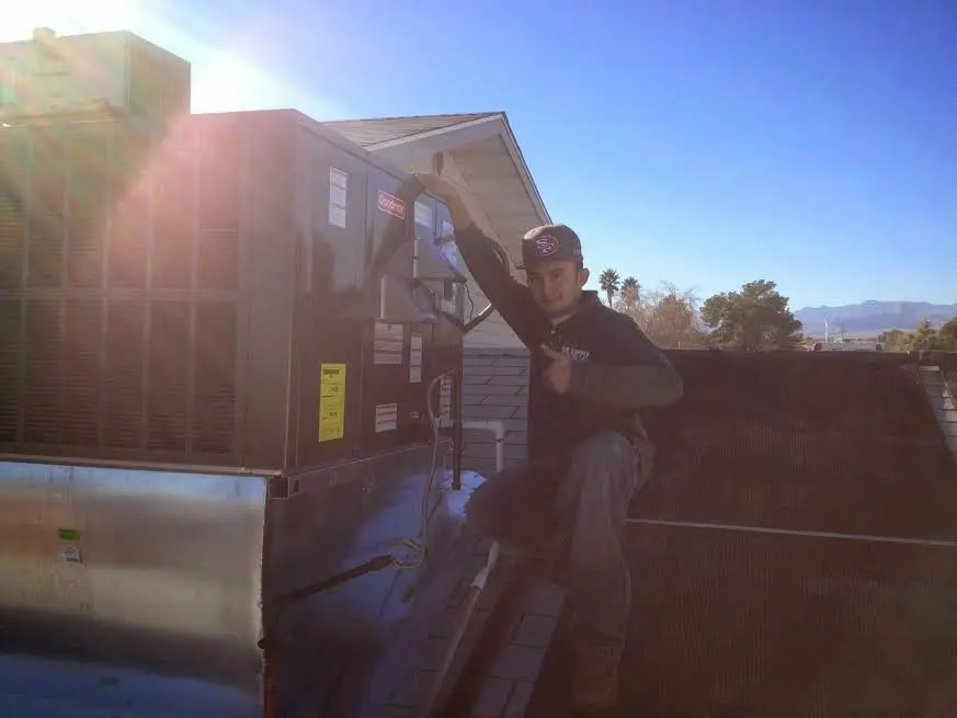 HVAC technician performing Air Duct Repair on a rooftop unit in Wetumpka