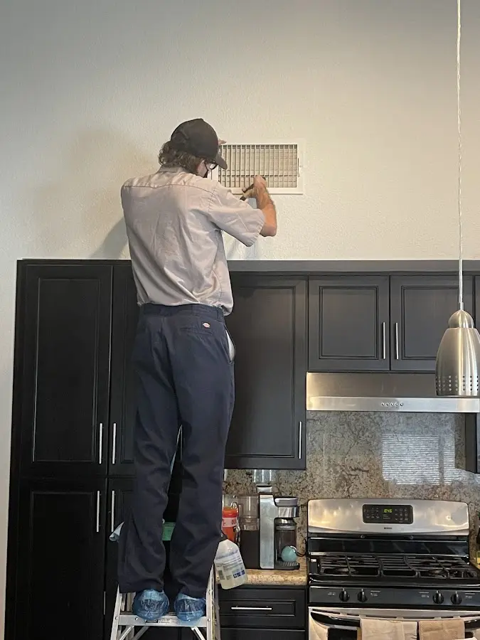 Technician inspecting an air vent during HVAC service in Wetumpka